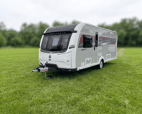 Coachman caravan that is on grasswith trees surrounding the field